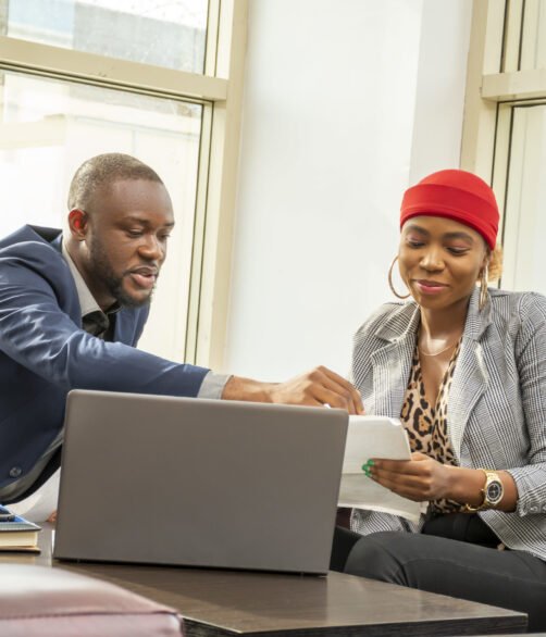 Young black businessman and woman going through some paperwork together