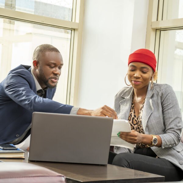 Young black businessman and woman going through some paperwork together