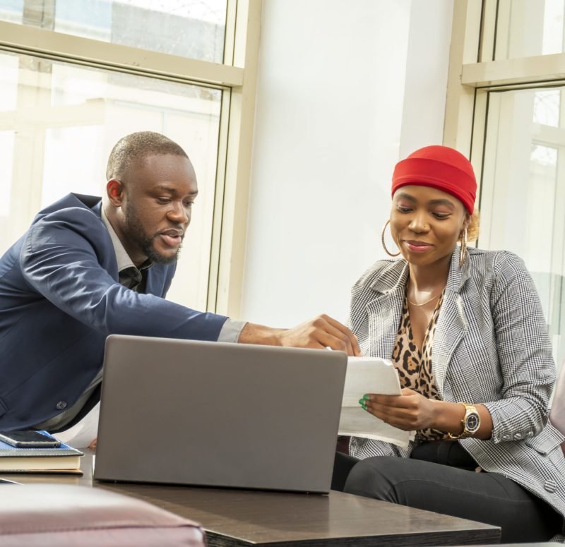 Young black businessman and woman going through some paperwork together